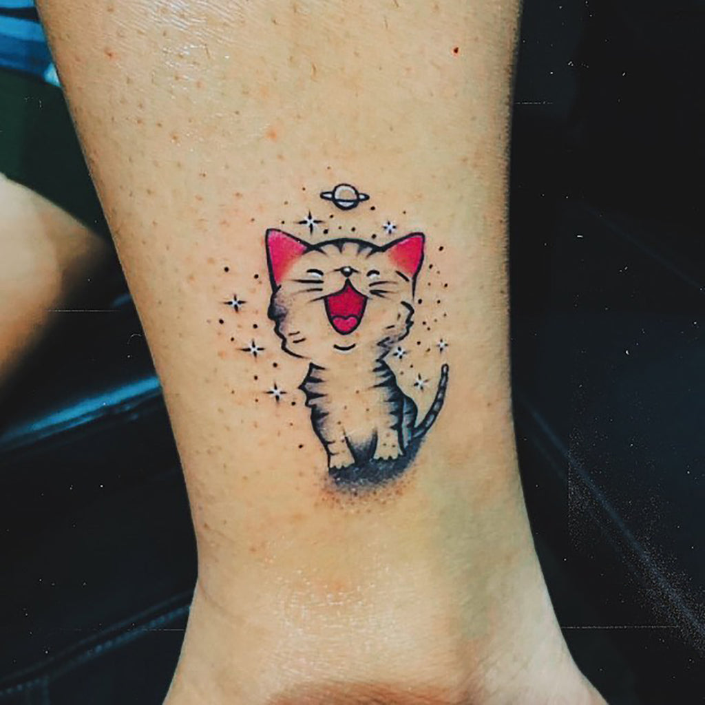 Happy cartoon tattoo of cat on ankle
